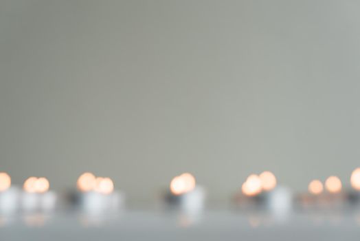 Blurry, abstract view of tealights on table