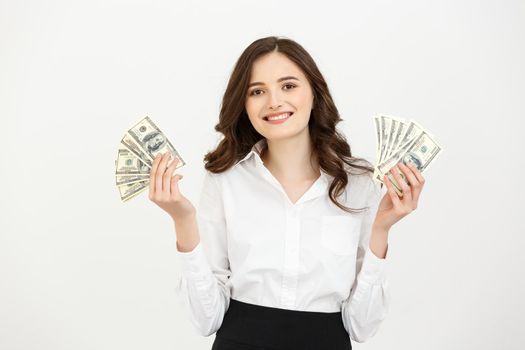 Portrait of a cheerful young business woman holding money banknotes and celebrating isolated over white background
