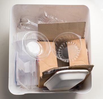 High angle view of home recycling bin with cardboard and plastic