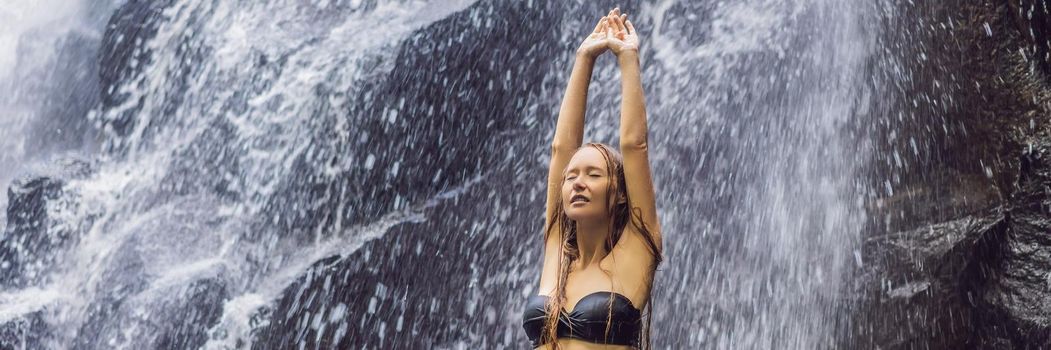 Woman traveler on a waterfall background. Ecotourism concept. BANNER, LONG FORMAT