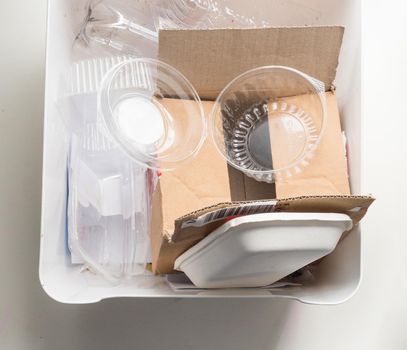 High angle cropped view of home recycling bin with cardboard and plastic