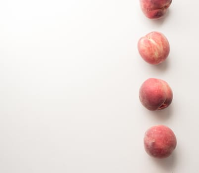 High angle view of white peaches arranged in a column on table with copy space to left