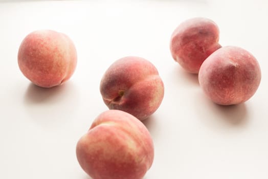 Close up of five white peaches on table (selective focus)