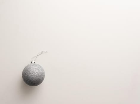 High angle view of silver christmas tree ball on white table (selective focus)