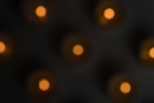 Blurry, abstract, high angle view of tealights on table in the dark