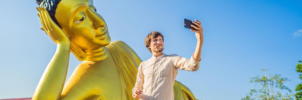 Happy man tourist on background ofLying Buddha statue. BANNER, LONG FORMAT