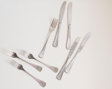 Food background - high angle view of four forks and knives on white table
