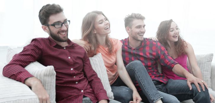 group of smiling young people sitting on the couch. best friends.