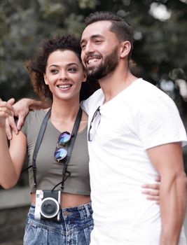 Happy young couple walking in the summer park