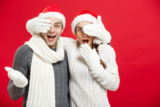 Christmas Concept - Young happy stylish couple in winter clothes close eyes each others celebrating in Christmas day.