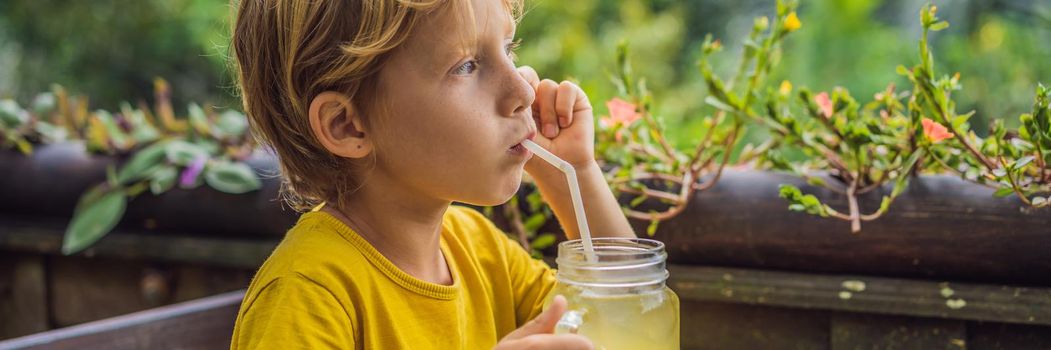 Boy drinking juice in a cafe. What to do with children. Child friendly place. BANNER, LONG FORMAT