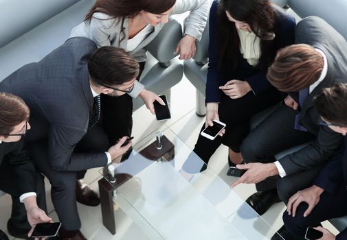 Young creative business people with smartphones in the office.