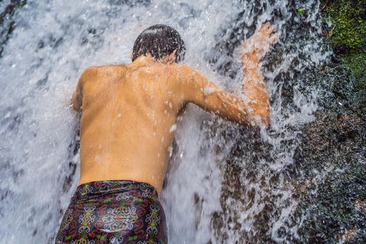 Young man tourist in Holy springs Sebatu in Bali.