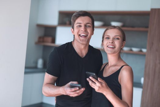 cheerful young couple reading email on smartphone. people and technology