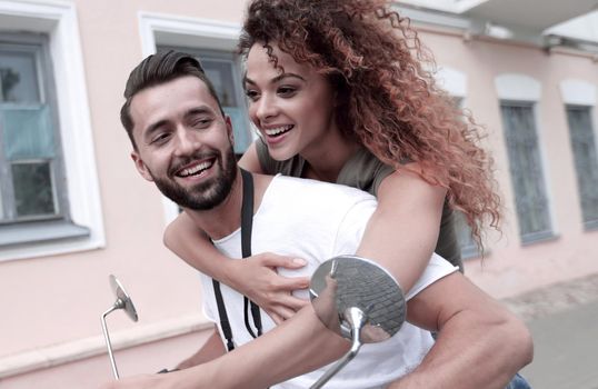 Happy young couple having summer trip on a scooter