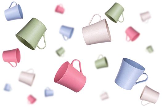 A lot of different colored plastic mugs flying in the air at different distances on a white background. Selected focus, background blur.