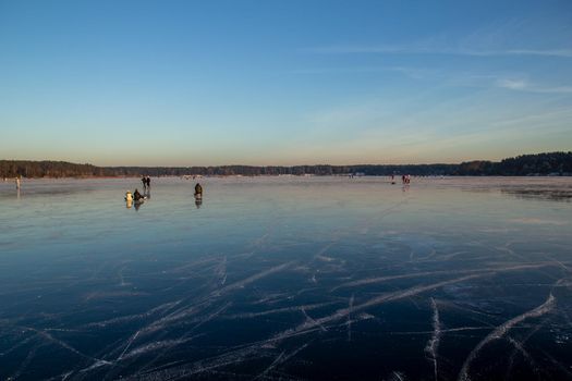 people ride and have fun on the frozen winter lake. winter entertainment