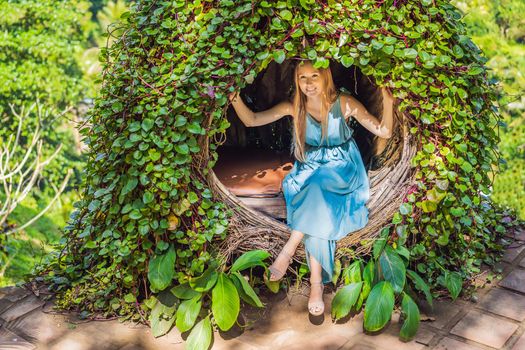 Bali trend, straw nests everywhere. Young tourist enjoying her travel around Bali island, Indonesia. Making a stop on a beautiful hill. Photo in a straw nest, natural environment. Lifestyle.