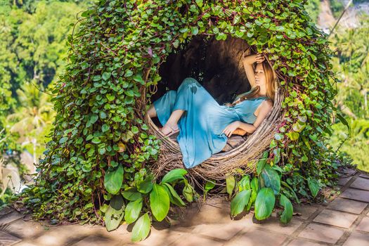 Bali trend, straw nests everywhere. Young tourist enjoying her travel around Bali island, Indonesia. Making a stop on a beautiful hill. Photo in a straw nest, natural environment. Lifestyle.