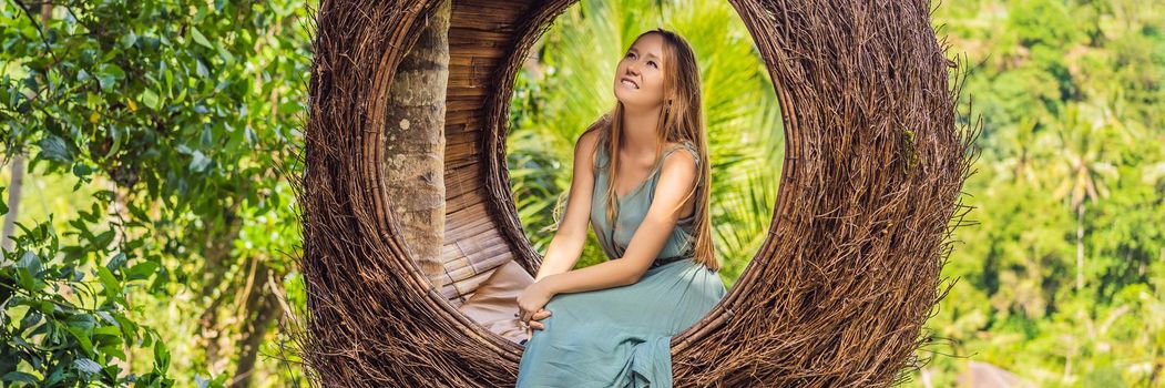 BANNER, LONG FORMAT Bali trend, straw nests everywhere. Young tourist enjoying her travel around Bali island, Indonesia. Making a stop on a beautiful hill. Photo in a straw nest, natural environment. Lifestyle.