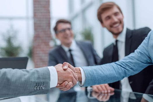 close up. business handshake on the background of applauding business team. concept of partnership