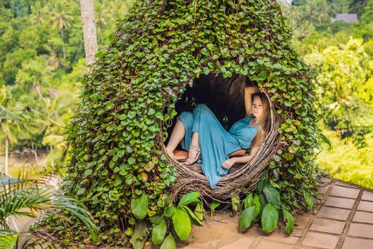 Bali trend, straw nests everywhere. Young tourist enjoying her travel around Bali island, Indonesia. Making a stop on a beautiful hill. Photo in a straw nest, natural environment. Lifestyle.