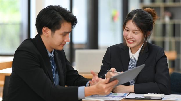 Two successful business people discussing business plans or sharing ideas together at modern office building.