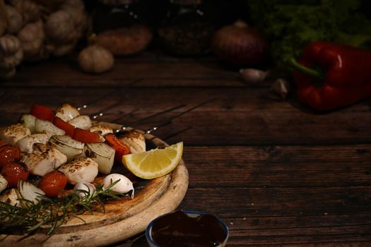 Chicken kebab, BBQ, skewers with cherry tomato, sweet pepper and onions on wooden plate. Barbecue, food, holiday concept.