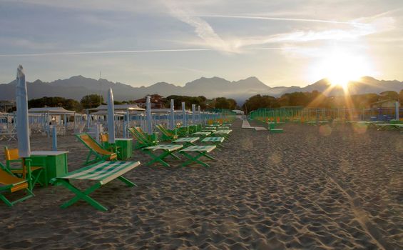 Forte dei Marmi beach at dawn with beach beds and closed umbrella