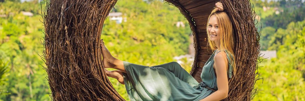 BANNER, LONG FORMAT Bali trend, straw nests everywhere. Young tourist enjoying her travel around Bali island, Indonesia. Making a stop on a beautiful hill. Photo in a straw nest, natural environment. Lifestyle.