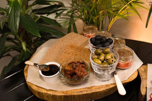 Black and green olives, sauces and dried bread, catering food. Treats in rustic style. Catering concept.