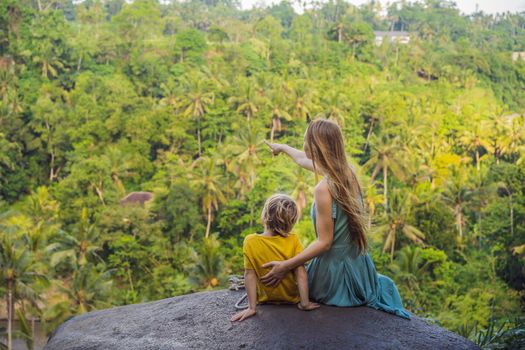 Mom and son tourists on a stone over the jungle. Traveling with kids concept. What to do with children. Child friendly place.