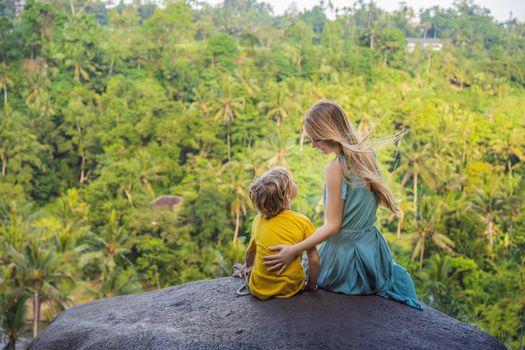 Mom and son tourists on a stone over the jungle. Traveling with kids concept. What to do with children. Child friendly place.