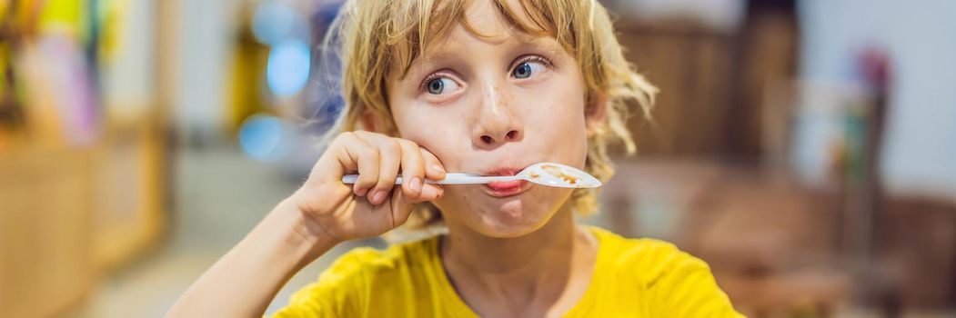 Boy eating ice cream in a cafe. BANNER, LONG FORMAT