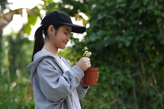 Smiling Asian Child hands holding potted. Ecology, Earth day, Hobbies, Leisure, Home gardening concept.