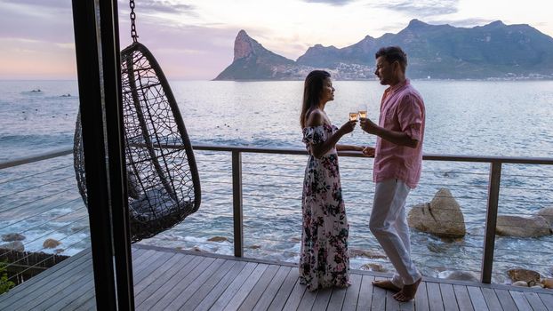 couple man and women drinking coffee during on balcony sunrise at vacation in Cape Town South Africa.