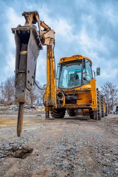 Excavator with hydraulic breaker hammer for the destruction of concrete and hard rock at the construction site or quarry. Demolition equipment