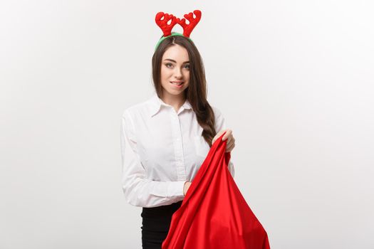 Christmas Concept - Young beautiful business woman excite with present in santa bag.
