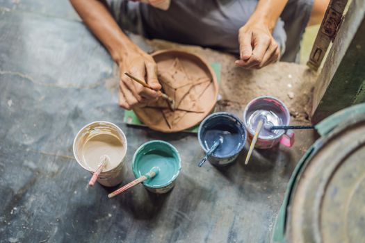 mother and son doing ceramic pot in pottery workshop.