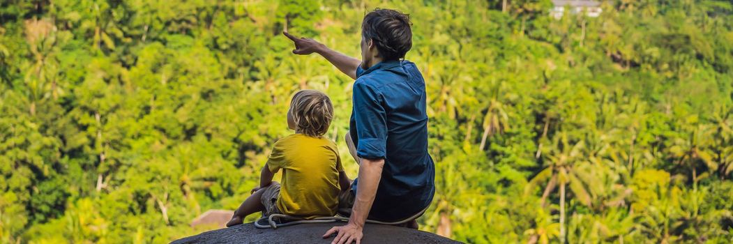 Dad and son tourists on a stone over the jungle. Traveling with kids concept. What to do with children. Child friendly place. BANNER, LONG FORMAT