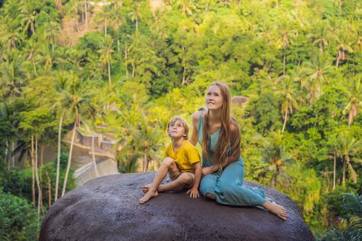 Mom and son tourists on a stone over the jungle. Traveling with kids concept. What to do with children. Child friendly place.