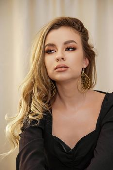 Beautiful young blonde woman face closeup portrait in studio on a light background.