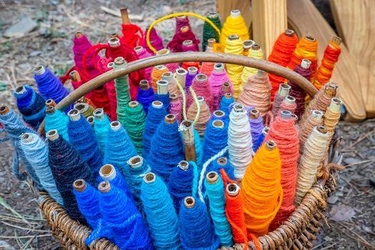 Colored thread spools of thread, textiles, background. Set of colored threads for sewing in a basket.
