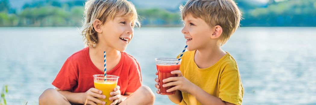BANNER, LONG FORMAT Two boys drink healthy smoothies against the backdrop of palm trees. Mango and watermelon smoothies. Healthy nutrition and vitamins for children.