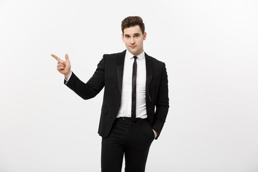 Business Concept: Close up portrait of young successful brunete stock-market broker guy or businessman pointing on a copyspace with his finger on white background