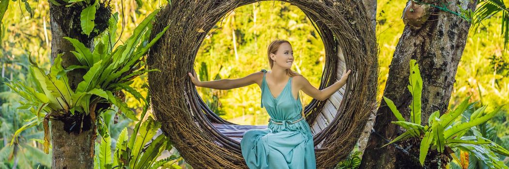 BANNER, LONG FORMAT Bali trend, straw nests everywhere. Young tourist enjoying her travel around Bali island, Indonesia. Making a stop on a beautiful hill. Photo in a straw nest, natural environment. Lifestyle.