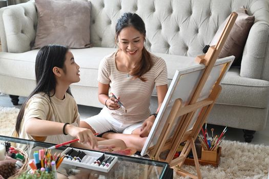 Happy asian girl enjoy painting picture with her mother at home.