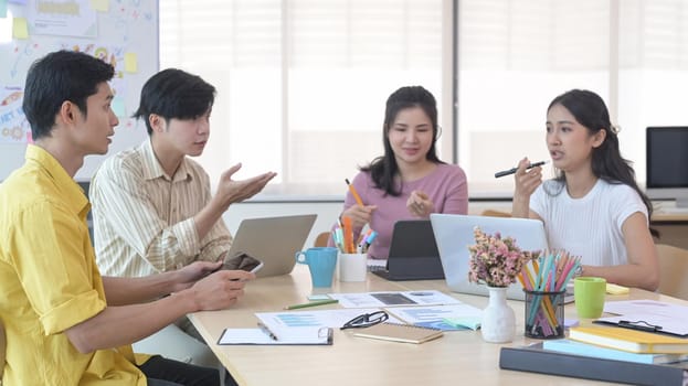 Startup business team brainstorming and working on new project together in modern bright office interior.