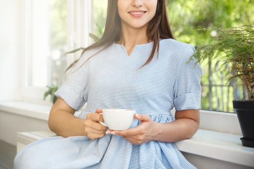 Young beautiful Caucasian lady enjoy drinking and having dessert in modern coffee shop at morning time.