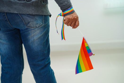 Asian woman with rainbow flag, LGBT symbol rights and gender equality, LGBT Pride Month in June.